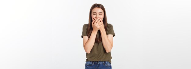 Donna felice che ride coprendosi la bocca con le mani isolare su sfondo grigio