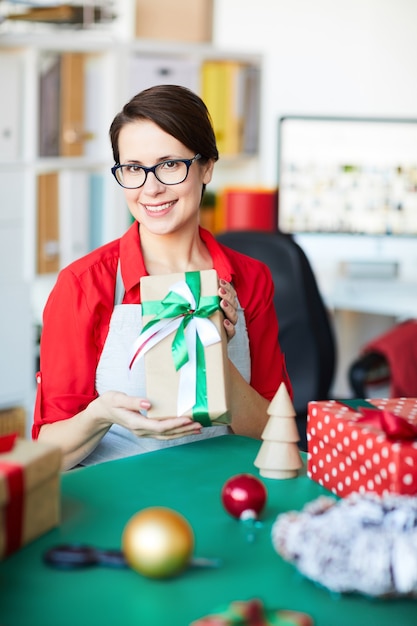 Donna felice che tiene un regalo o un regalo di Natale