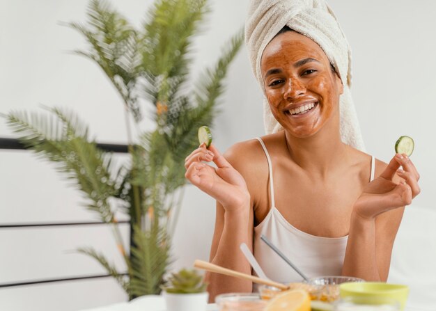 Donna felice che utilizza una maschera facciale naturale