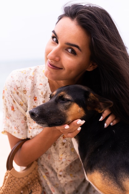 Donna felice con cane da spiaggia