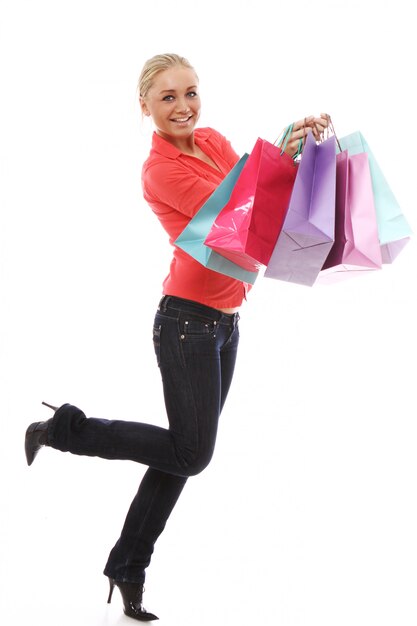 Donna felice con i sacchetti della spesa variopinti