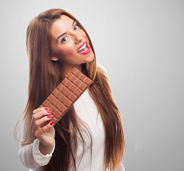 donna felice con la barra di cioccolato al latte