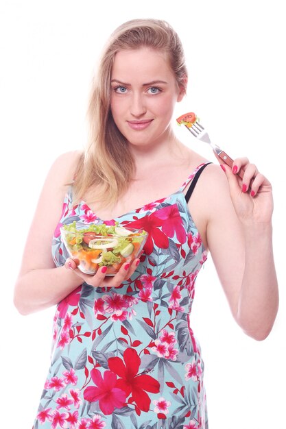 Donna felice con la ciotola di insalata fresca