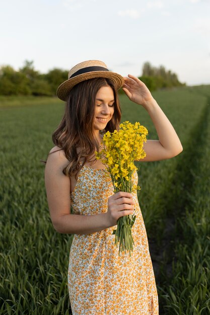 Donna felice del colpo medio che tiene i fiori