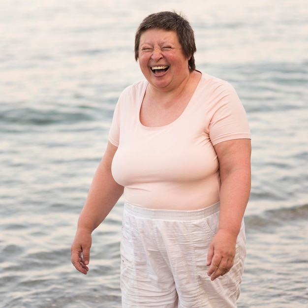 Donna felice del colpo medio in riva al mare