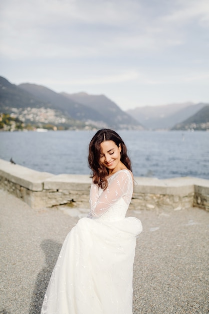 Donna felice della sposa in una posa del vestito da sposa