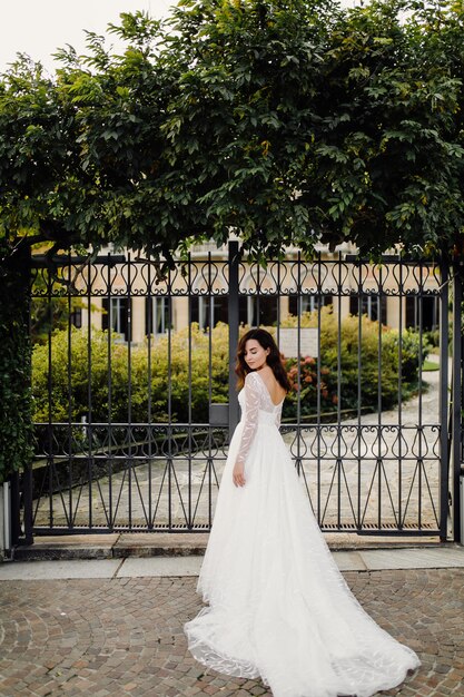 Donna felice della sposa in una posa del vestito da sposa