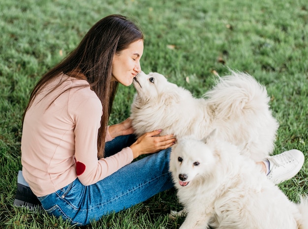 Donna felice di giocare con cani carini