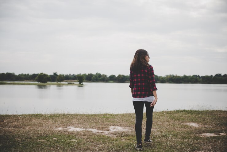 Foto gratuito donna felice hipster che cammina attraverso il lago sullo sfondo del campo estivo.