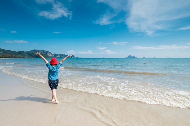 Donna felice sulla spiaggia e nuvole cielo.