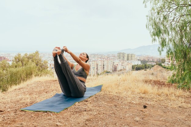 Donna flelxible facendo yoga all&#39;aperto