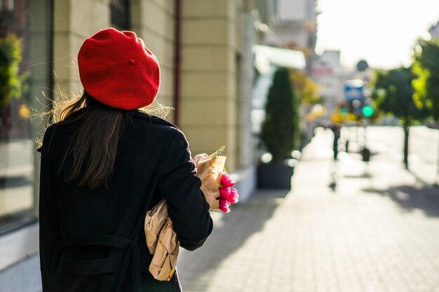 Donna francese con baguette sulla strada nel berretto