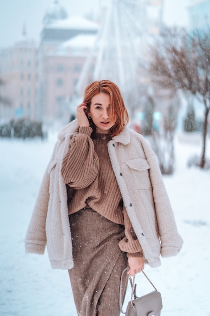 Donna fuori il giorno di inverno freddo di nevicata