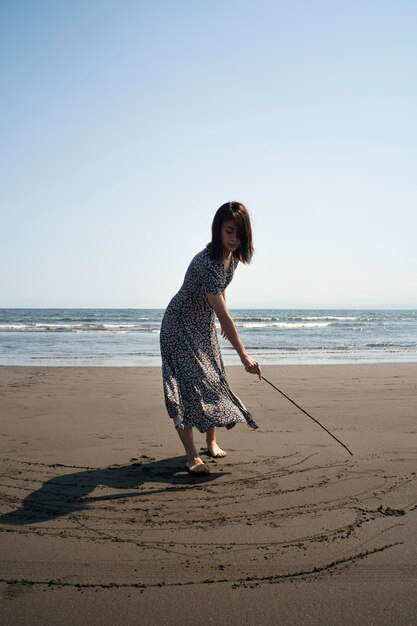 Donna giapponese a tutto campo in spiaggia