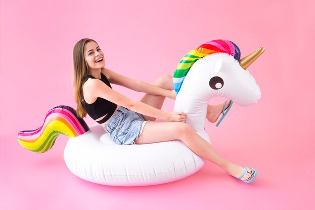 Donna gioiosa su unicorno gonfiabile