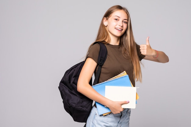 Donna giovane studente con borsa zaino tenendo la mano con il pollice in alto gesto, isolato sopra il muro bianco