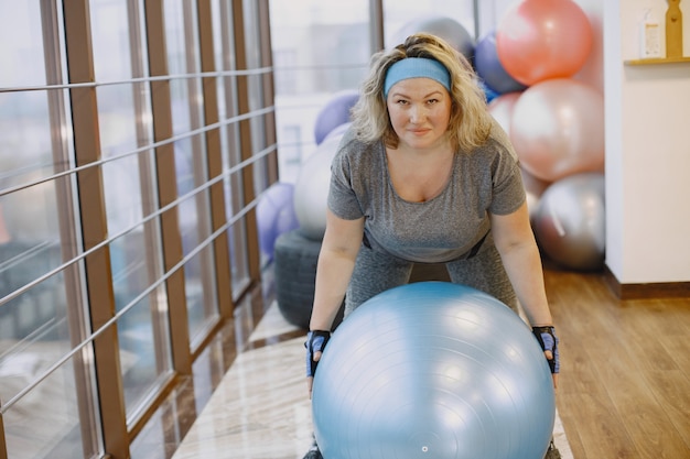 Donna grassa a dieta, fitness. Ritratto di donna obesa che lavora in palestra.