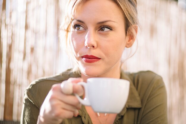 Donna graziosa che beve caffè sul ricorso