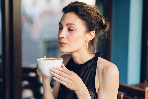 Donna graziosa che beve caffè