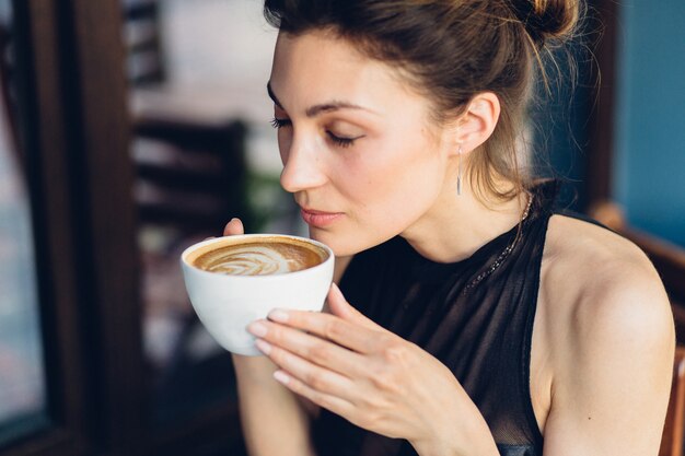 Donna graziosa che beve caffè