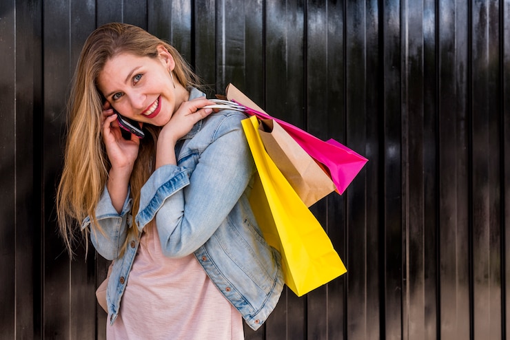 Foto gratuito donna graziosa con i sacchetti della spesa che parla dal telefono