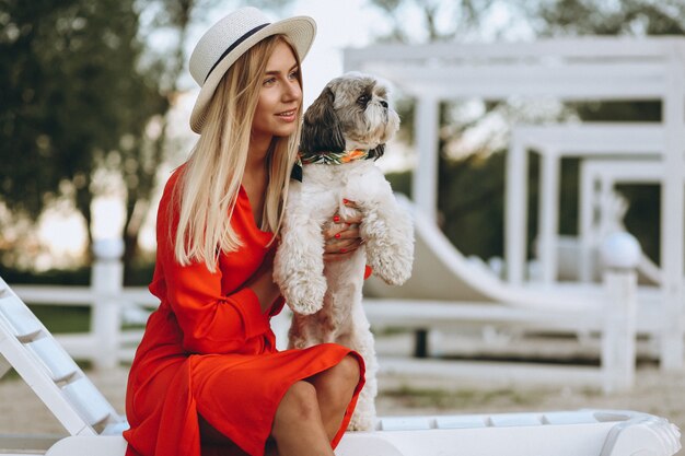 Donna graziosa con il suo cane carino in vacanza