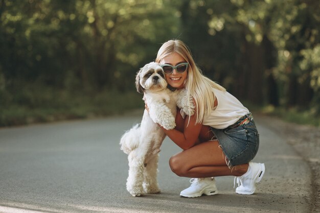 Donna graziosa con il suo cane fuori nel parco