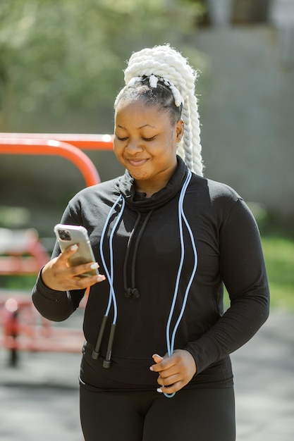 Donna in abiti sportivi che tiene uno smartphone