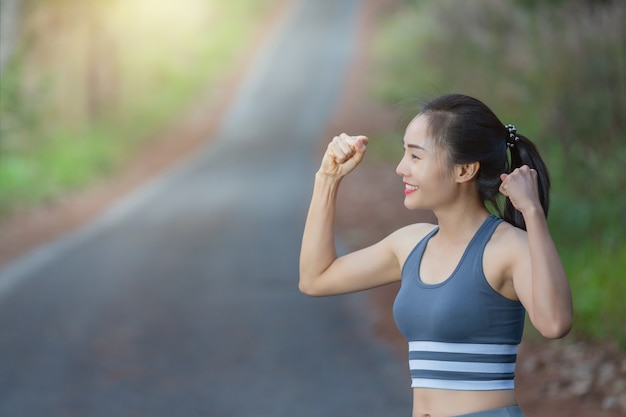 donna in abiti sportivi mostra bicipiti