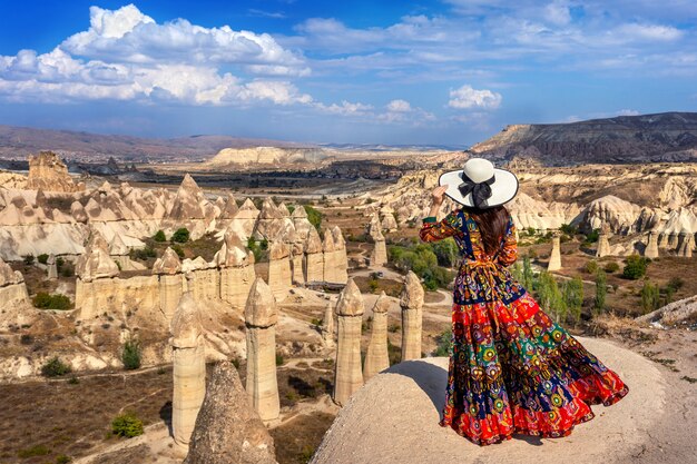 Donna in abito boemo in piedi sulla valle dell'amore in Cappadocia, Turchia.