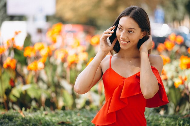 Donna in abito rosso utilizzando il telefono