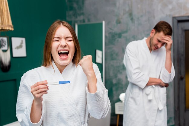 Donna in accappatoio entusiasta del test di gravidanza