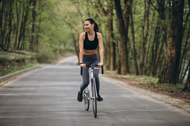 Donna in bicicletta nella foresta