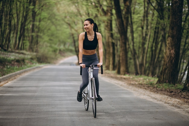 Donna in bicicletta nella foresta