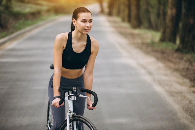 Donna in bicicletta nella foresta