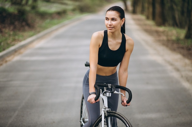 Donna in bicicletta nella foresta