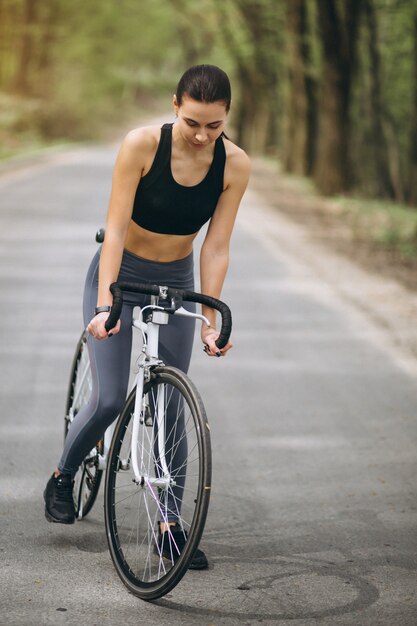 Donna in bicicletta nella foresta