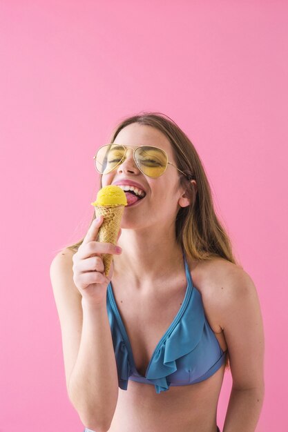 Donna in bikini che mangia il gelato