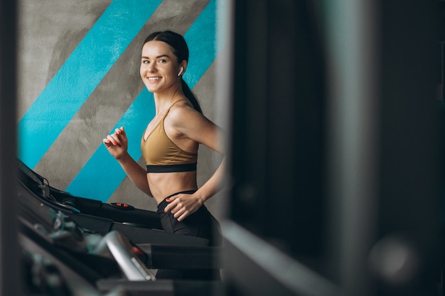 Donna in buona salute sulla pista corrente in palestra