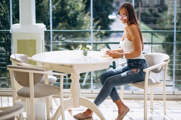 Donna in caffè con caffè e parlando al telefono