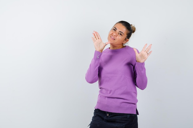 Donna in camicetta di lana agitando le mani per salutare e sembrare allegra