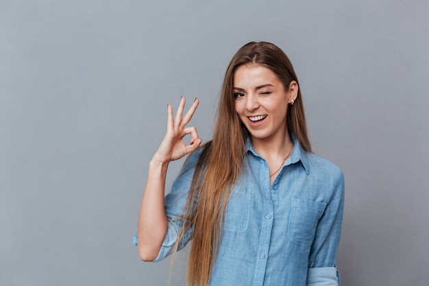 Donna in camicia che mostra segno giusto