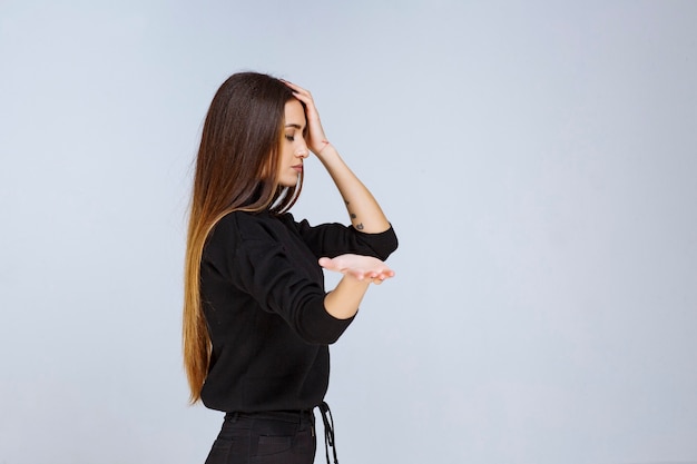 donna in camicia nera che dà pose neutre e civettuole.