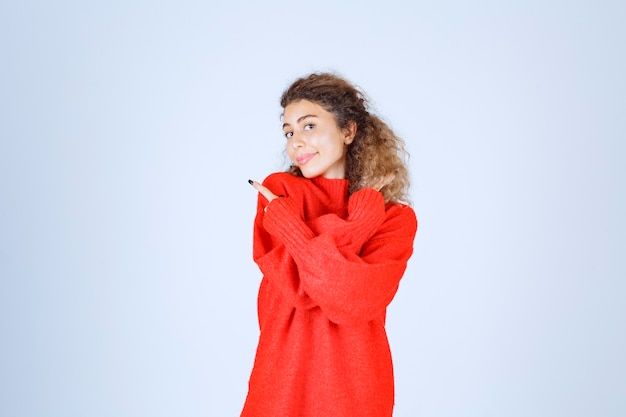 donna in camicia rossa che indica qualcosa a sinistra.