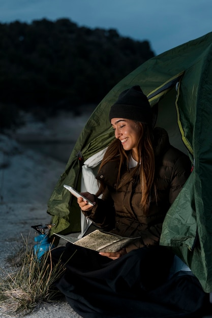 Donna in campeggio e utilizzando il telefono cellulare