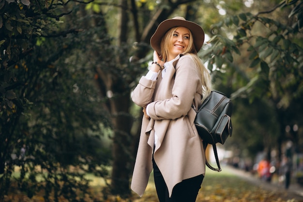 Donna in cappello e cappotto nel parco