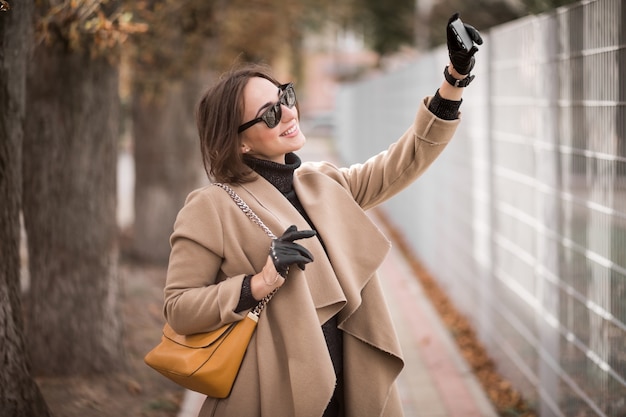 Donna in cappotto con il telefono