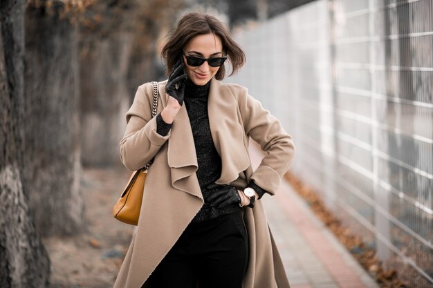 Donna in cappotto con il telefono