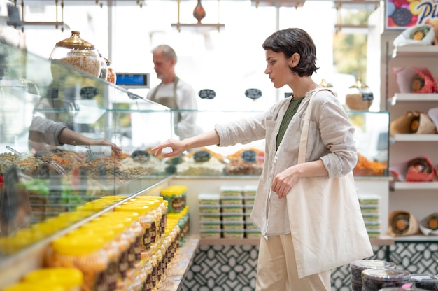 Donna in cerca di prelibatezze presso un produttore maschile locale