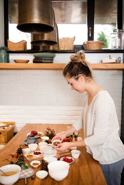 Donna in cucina con torta che decora gli ingredienti